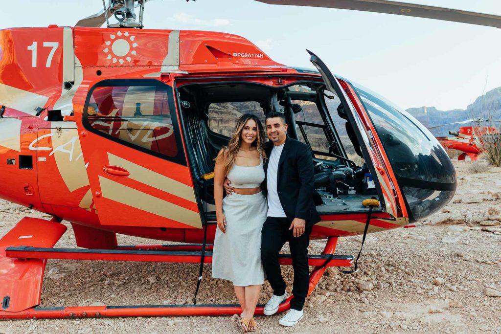Newly Engaged Couple in front of a helicopter