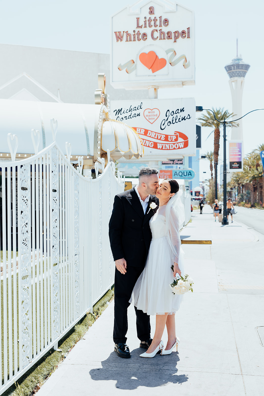 Bride and groom pose outside The Little White Wedding Chapel in Las Vegas