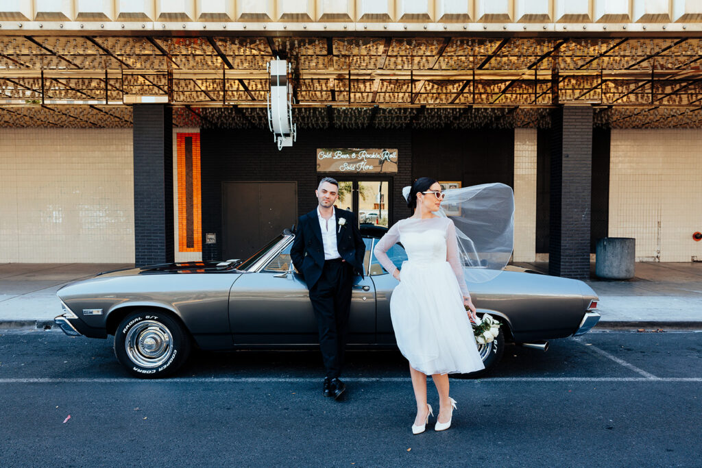 Vintage Vegas Wedding Scene with Bride, Groom, and Classic Car