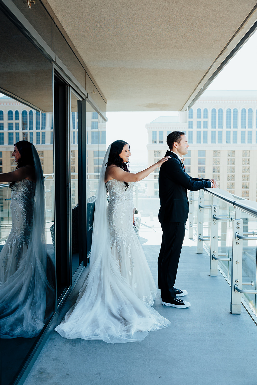 Bride approaching groom from behind during first look on balcony