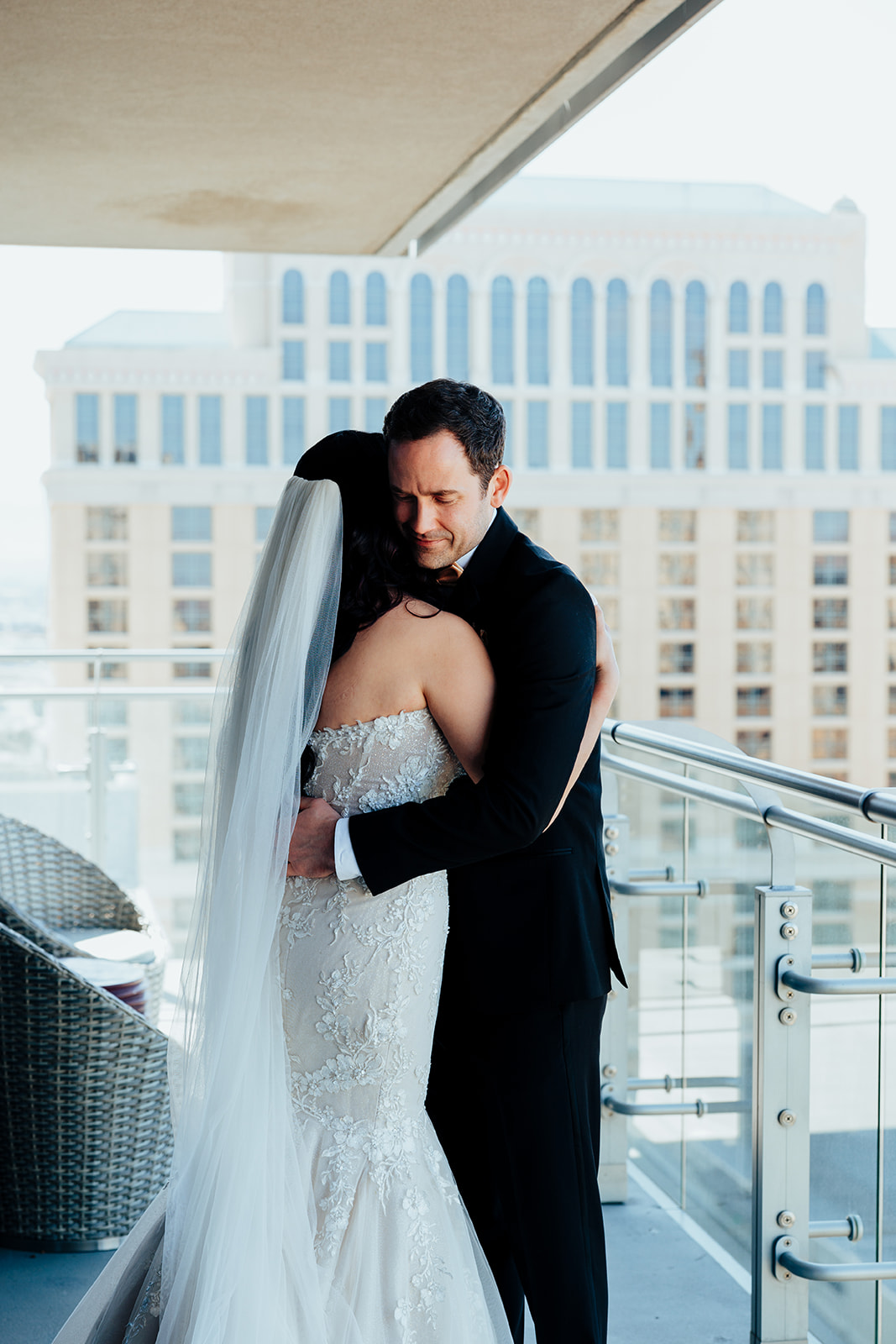 Bride and groom hugging on hotel balcony during their Las Vegas wedding