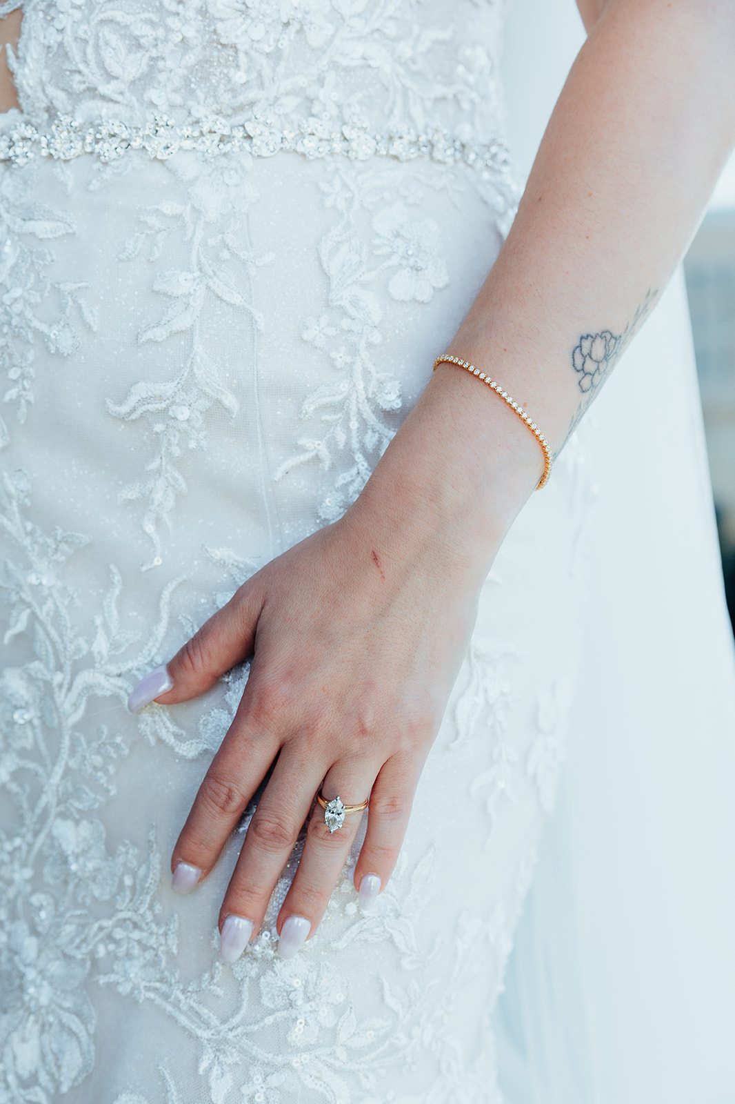 Close-up of bride’s hand with lace wedding gown and diamond ring in Las Vegas