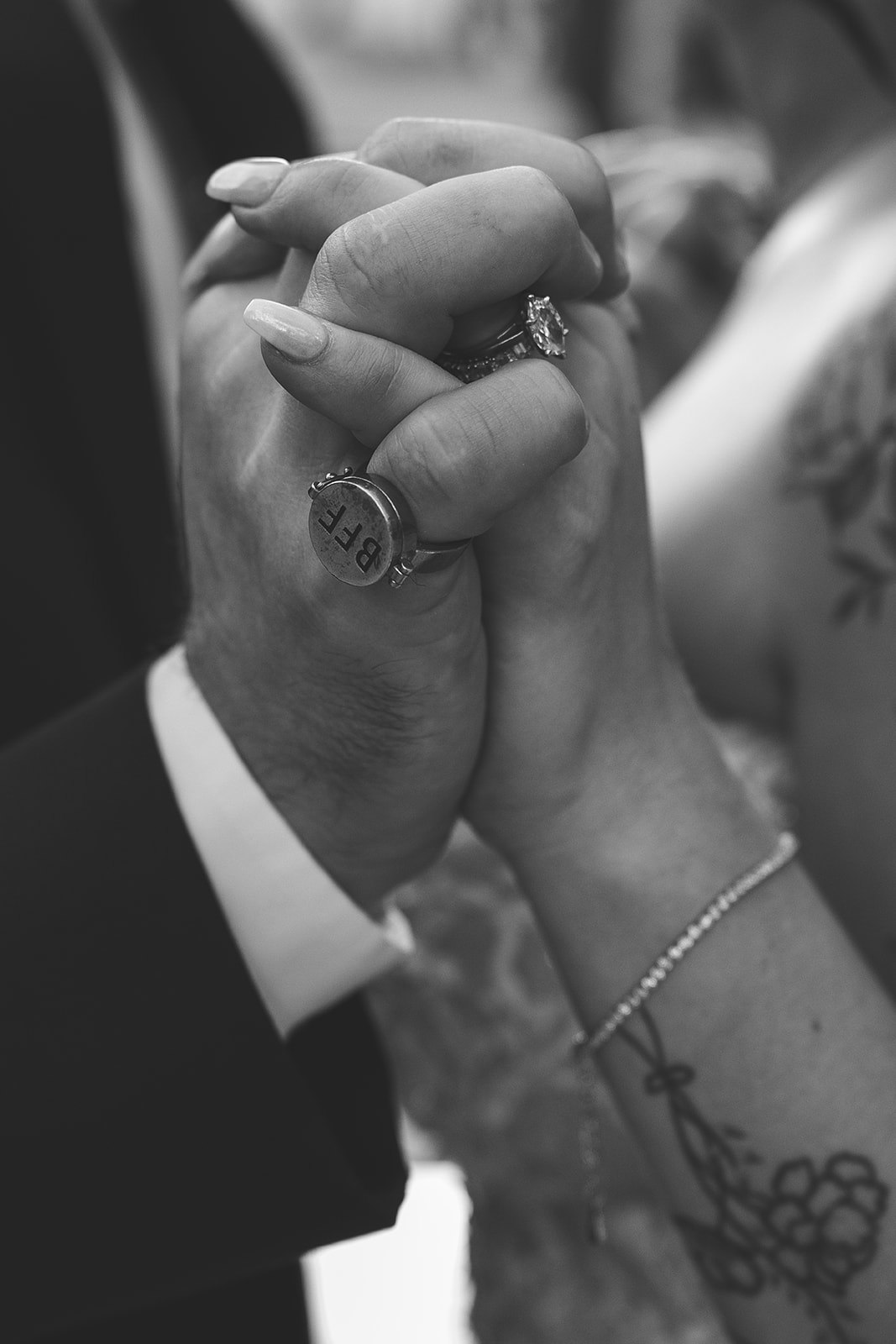 Black and white close-up of intertwined hands with wedding rings at Caesars Palace