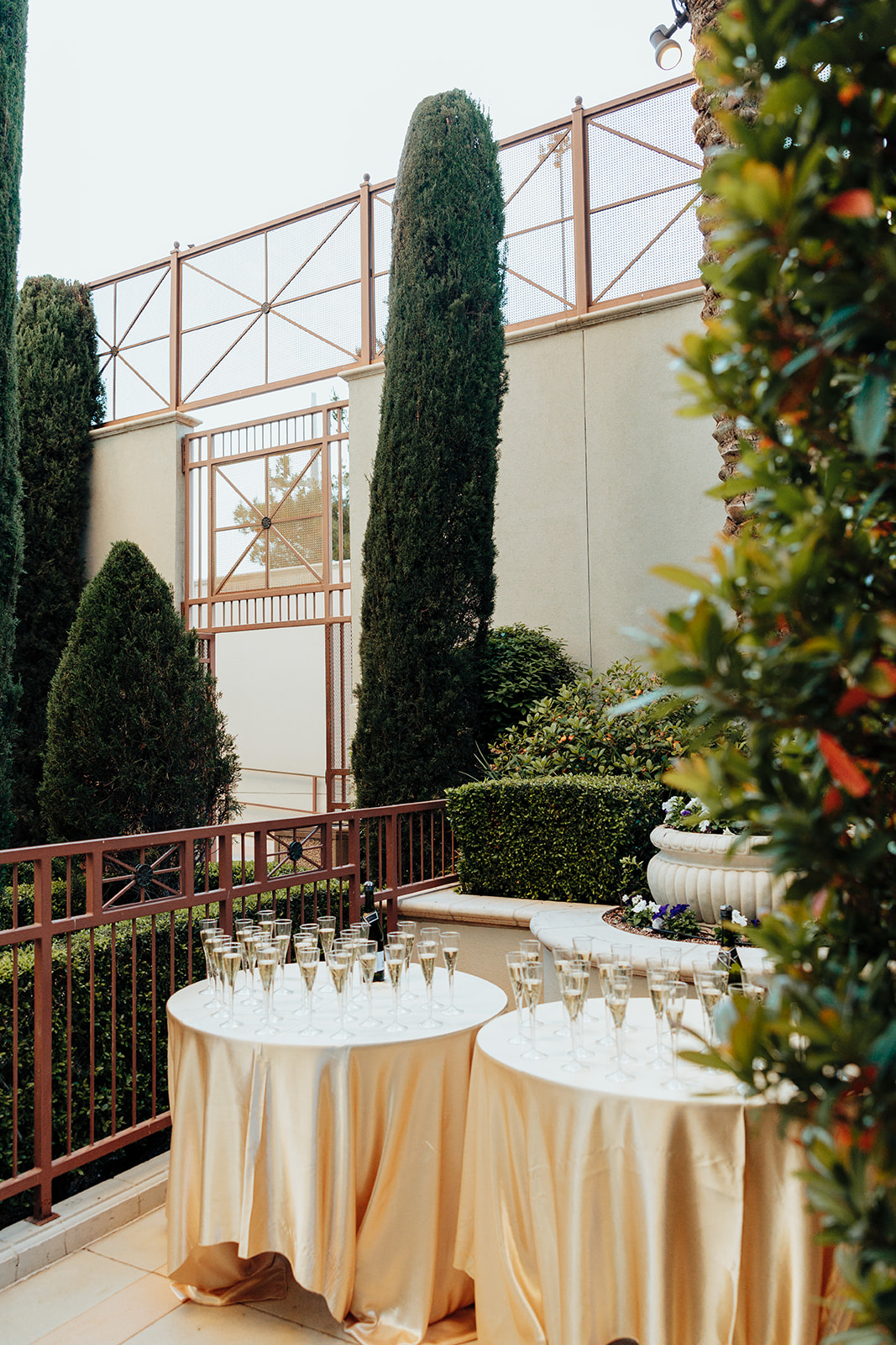 Champagne Glasses on Gold-Draped Tables in Garden Setting