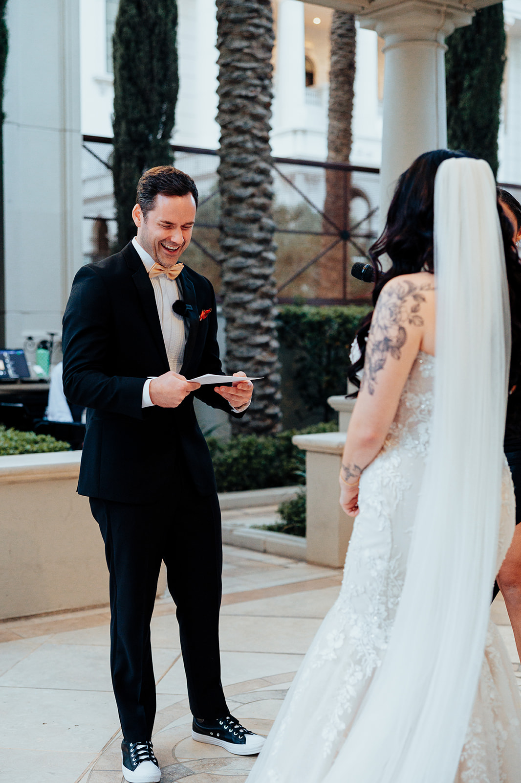 Groom Smiling While Reading Vows at Outdoor Wedding