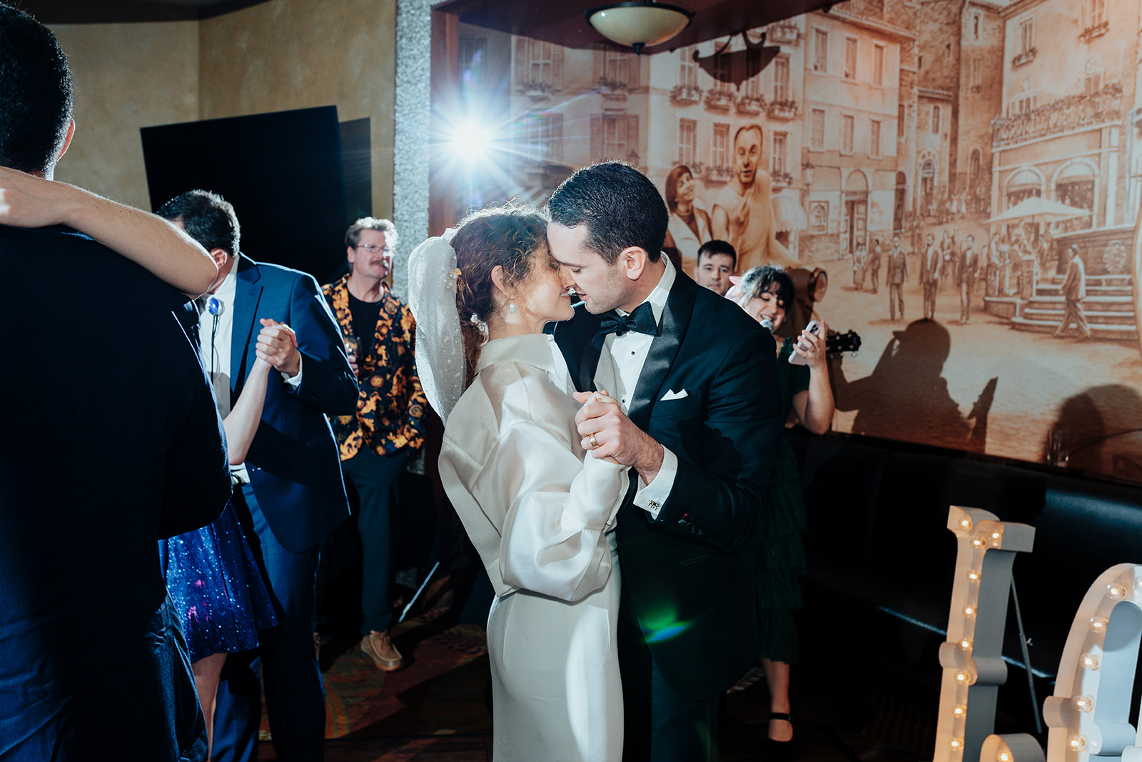 Bride and groom sharing an intimate dance during their wedding reception at Caesars Palace in Las Vegas, surrounded by smiling guests.