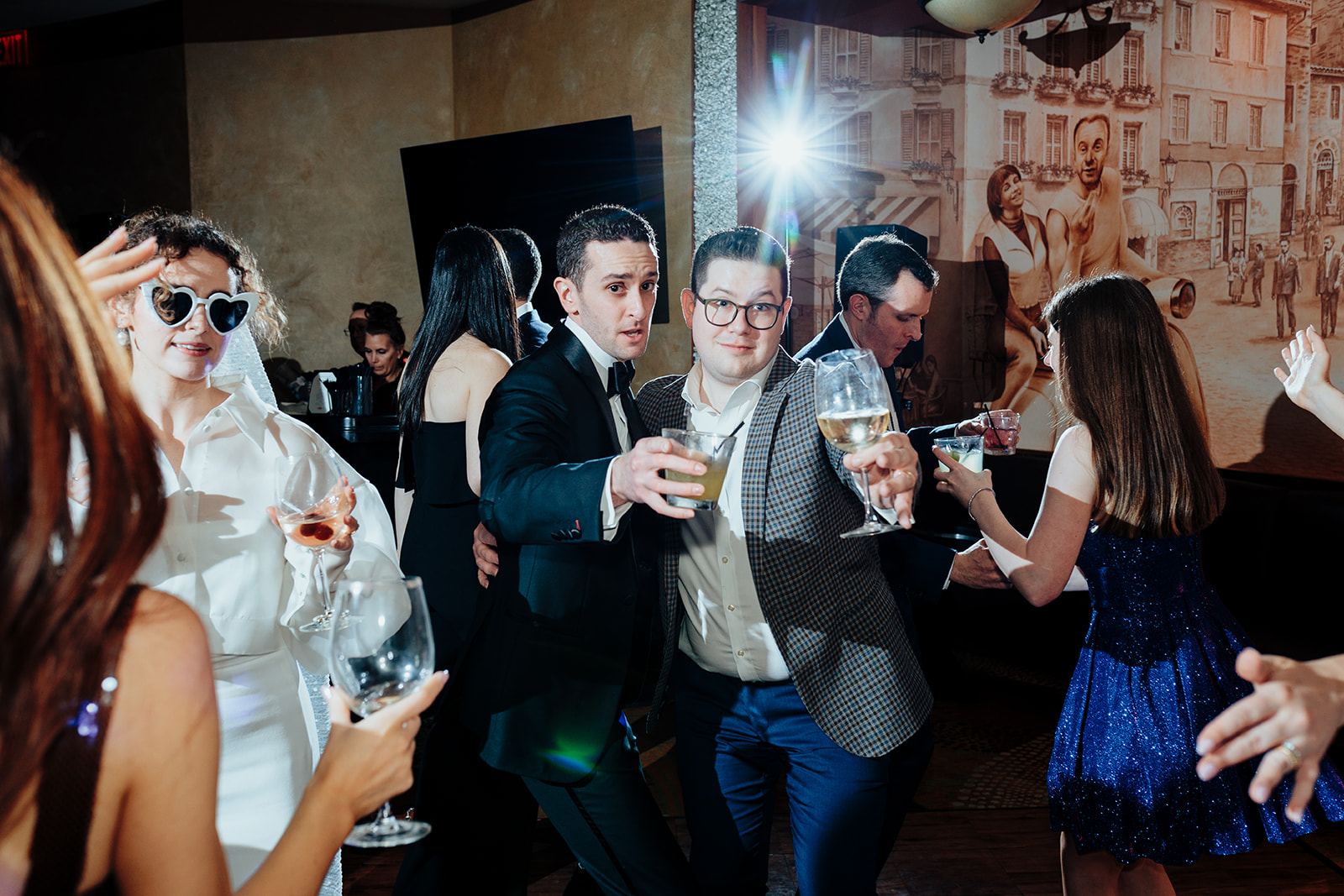 Groom and guests raising glasses in a toast on the dance floor during a lively Las Vegas wedding reception at Caesars Palace.