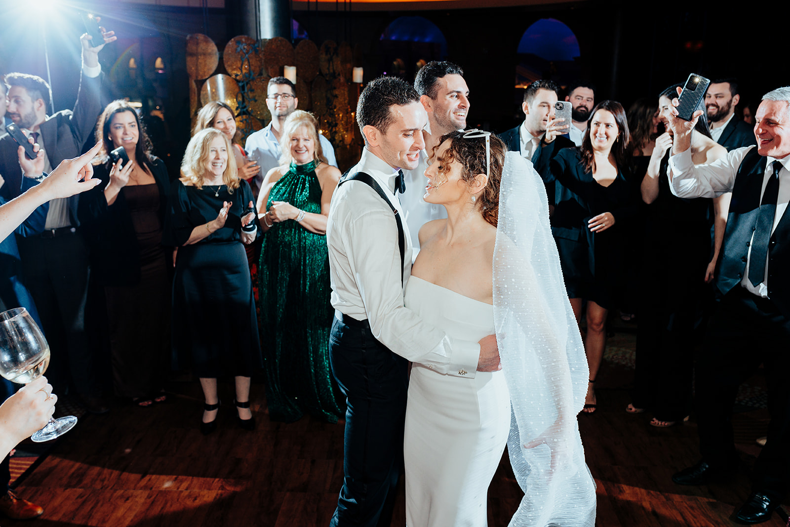 Bride and groom sharing a romantic moment on the dance floor surrounded by smiling guests during their Las Vegas wedding reception at Caesars Palace.