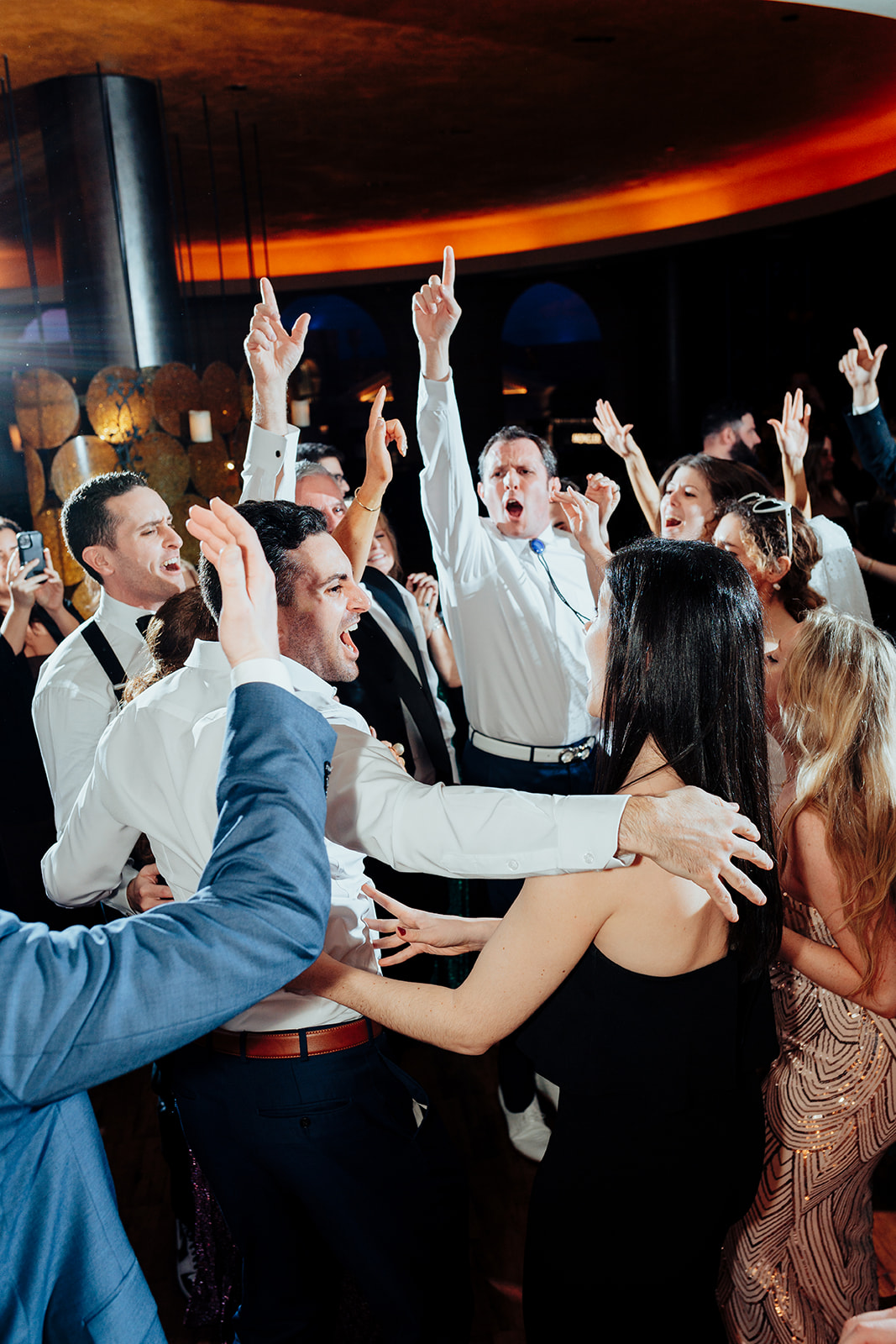 Wedding guests enthusiastically dancing and celebrating on the dance floor during a lively Las Vegas reception at Caesars Palace.