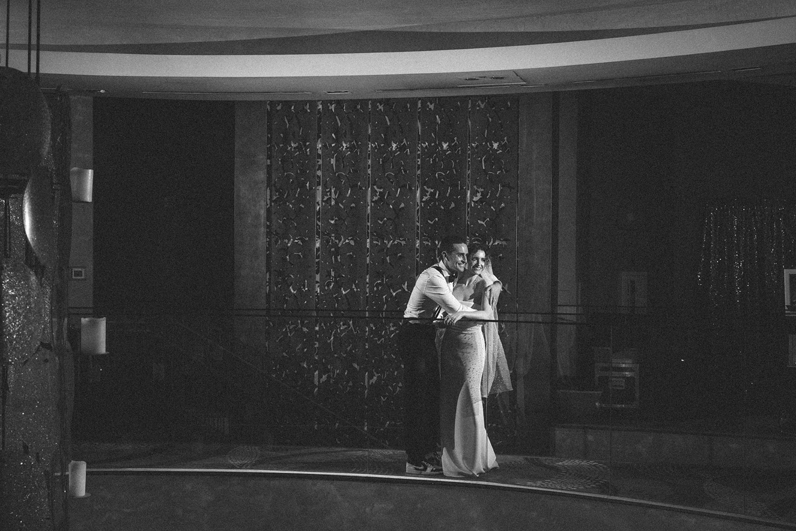 Bride and groom embracing during their first dance in a black and white photograph, capturing a romantic moment at their Las Vegas wedding reception.