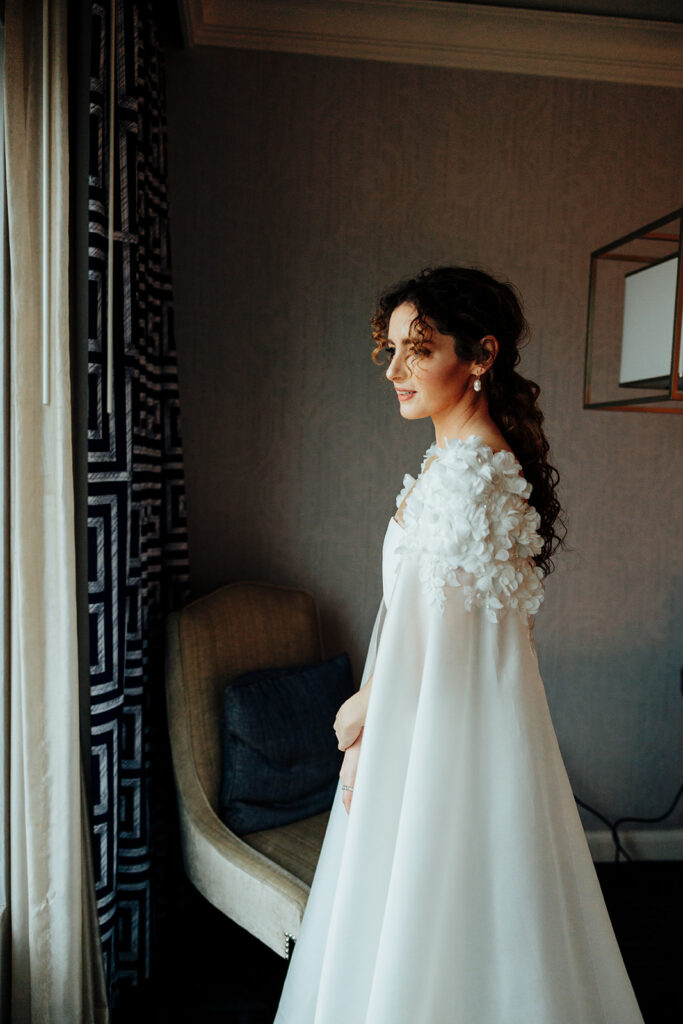 Elegant Bride Gazing Out Window in Wedding Gown