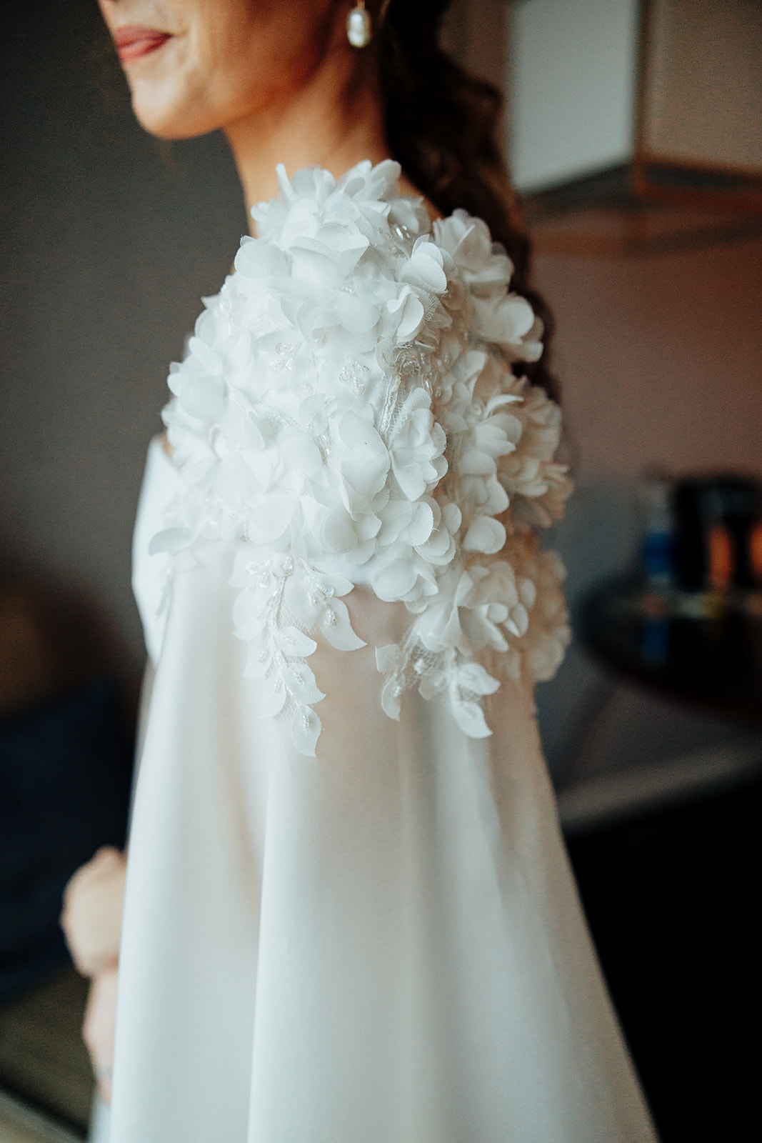 Close-up of a bride’s floral-embellished cape and pearl earring, captured for Las Vegas wedding photography.