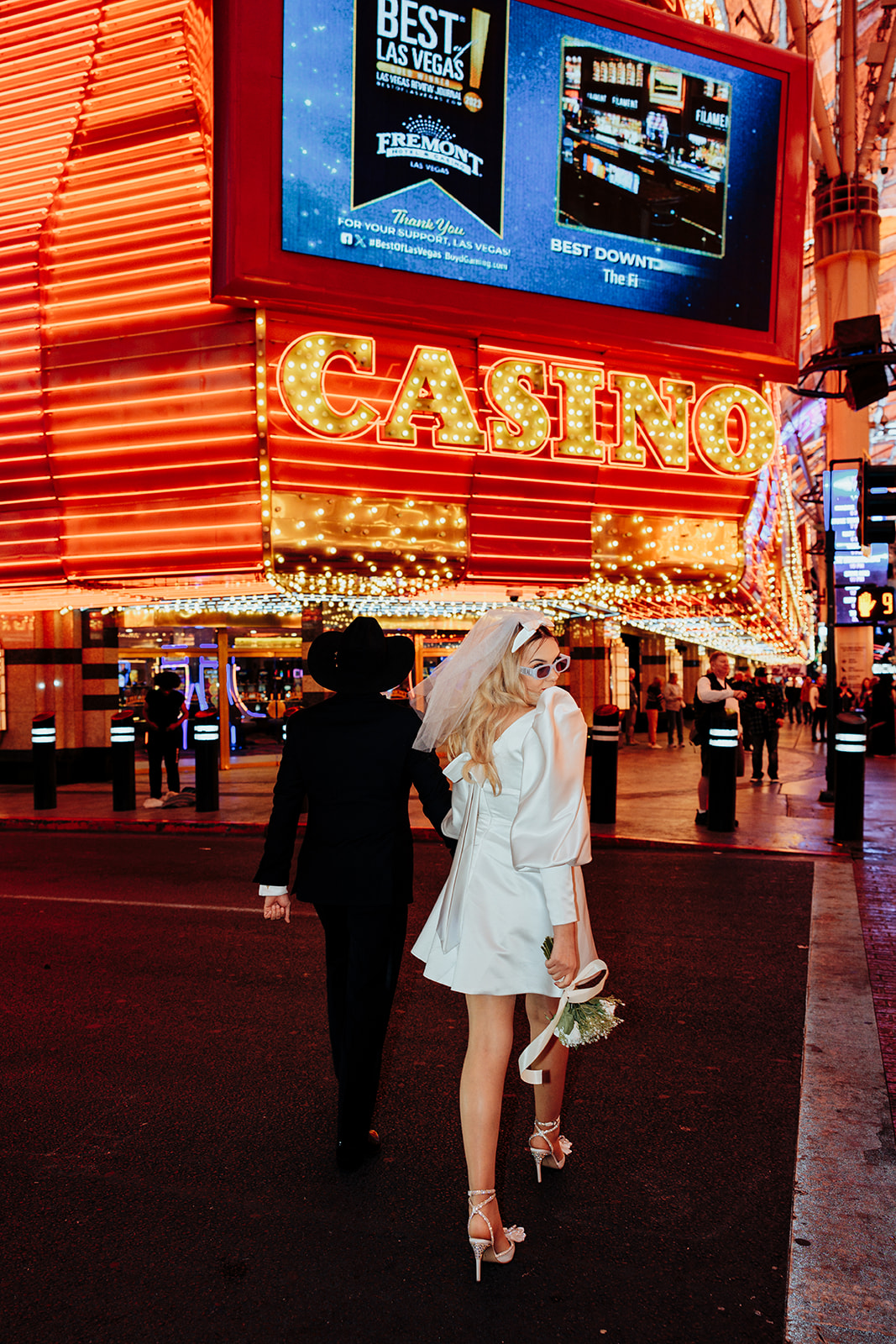 Newlyweds Strolling Under Neon Casino Lights in Vegas