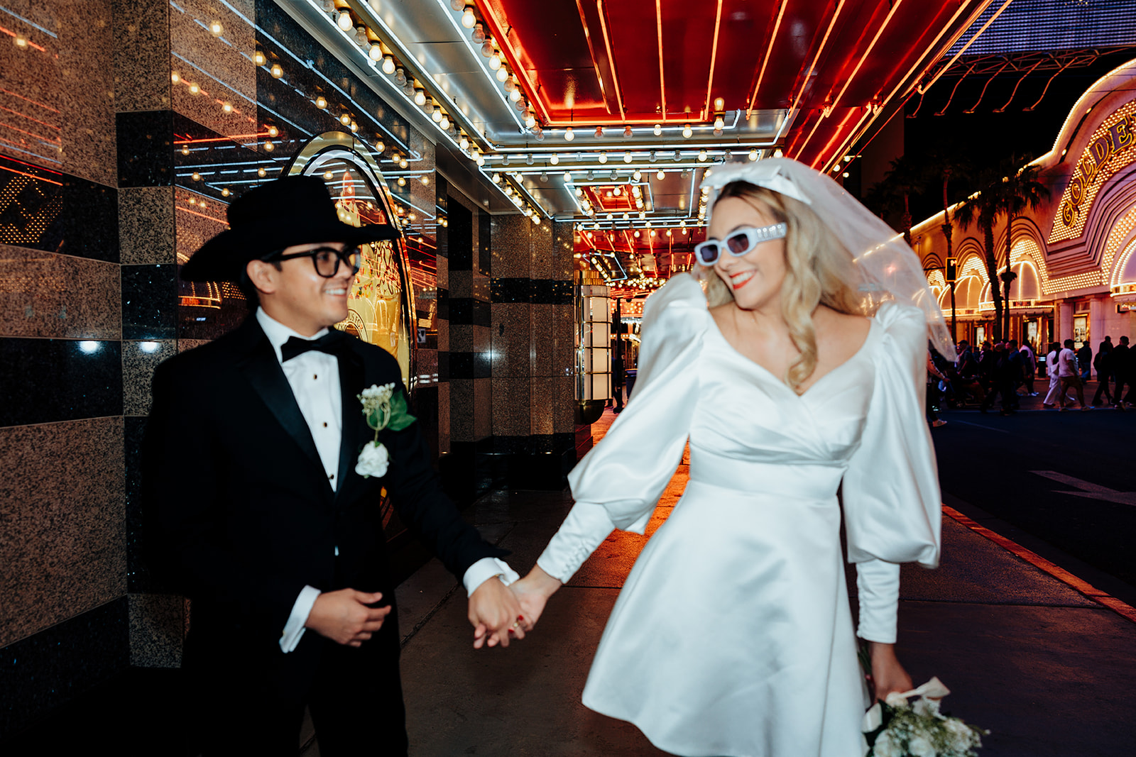 Bride and Groom Smiling While Walking Through Downtown Vegas