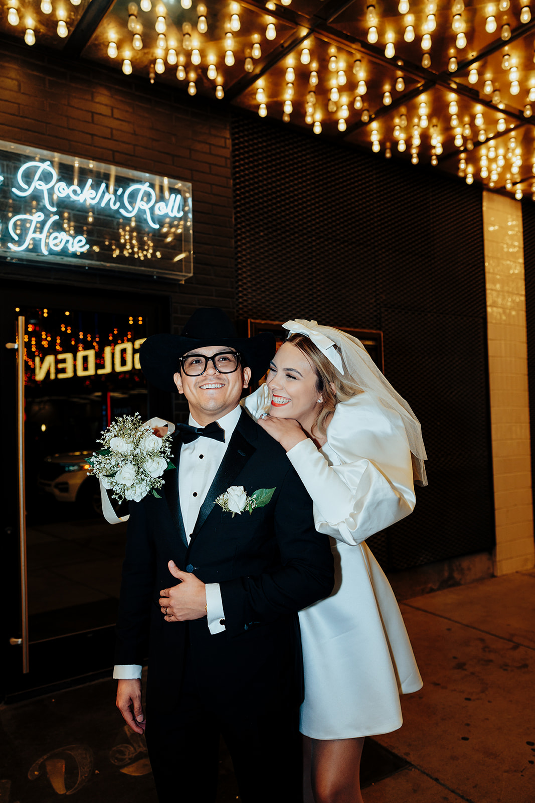 Newlywed Couple Laughing Under Vegas Marquee Lights