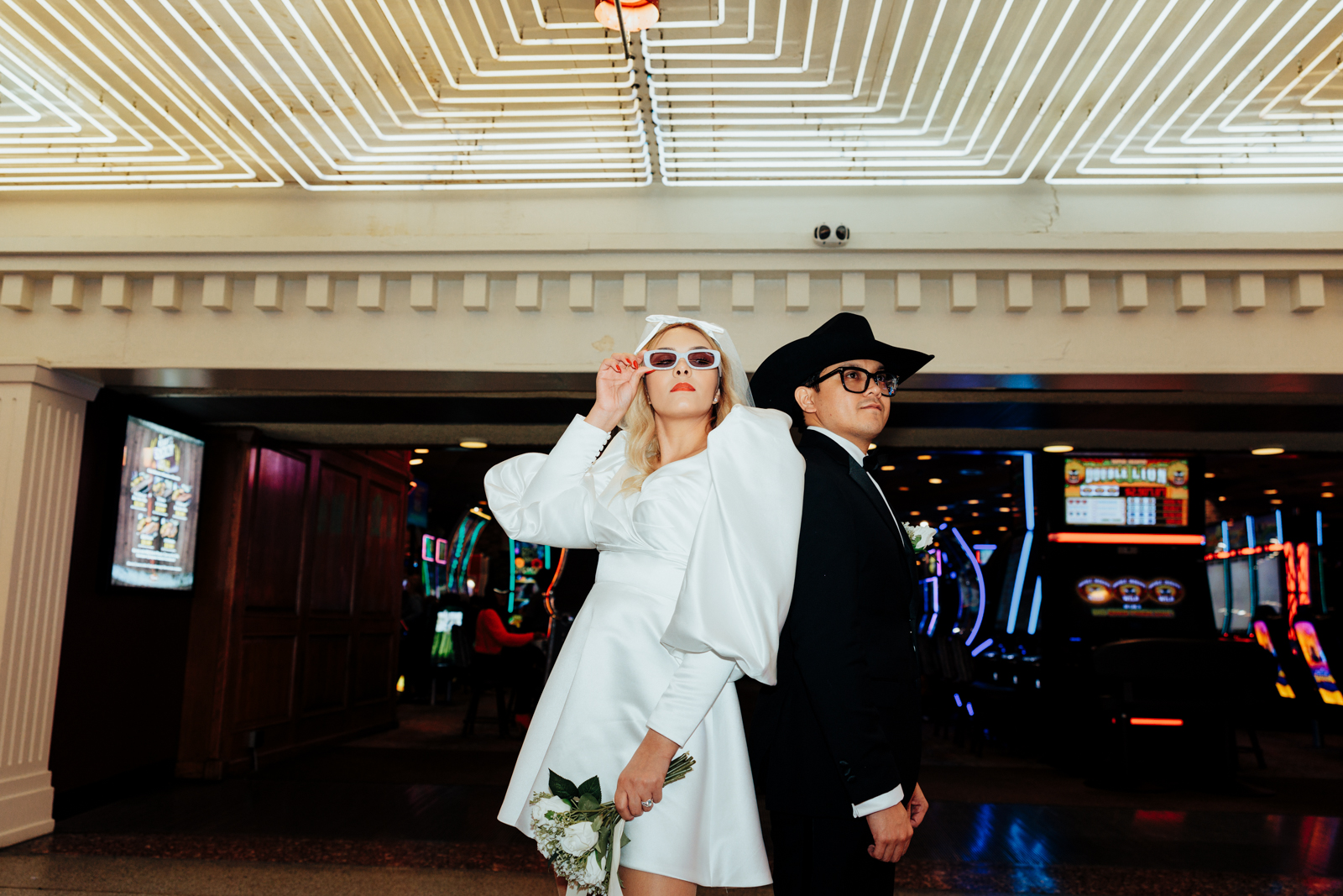 Bride and Groom Back to Back with Neon Casino Lights