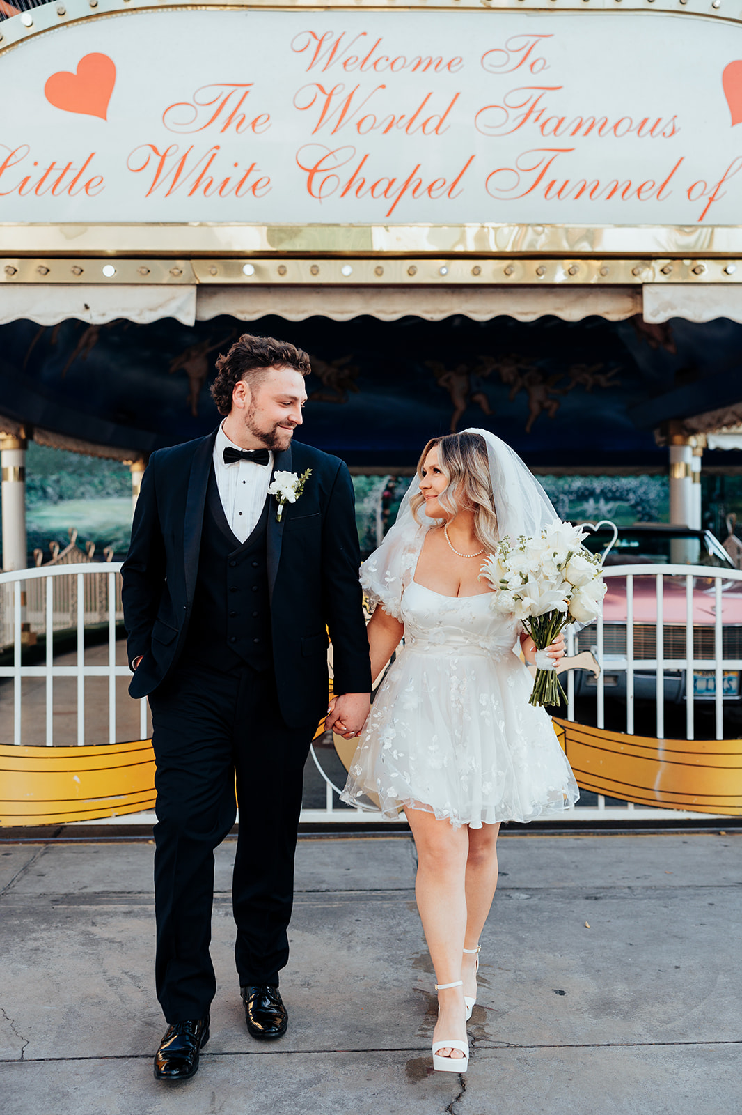 Couple walking toward Tunnel of Love during Little White Wedding Chapel elopement