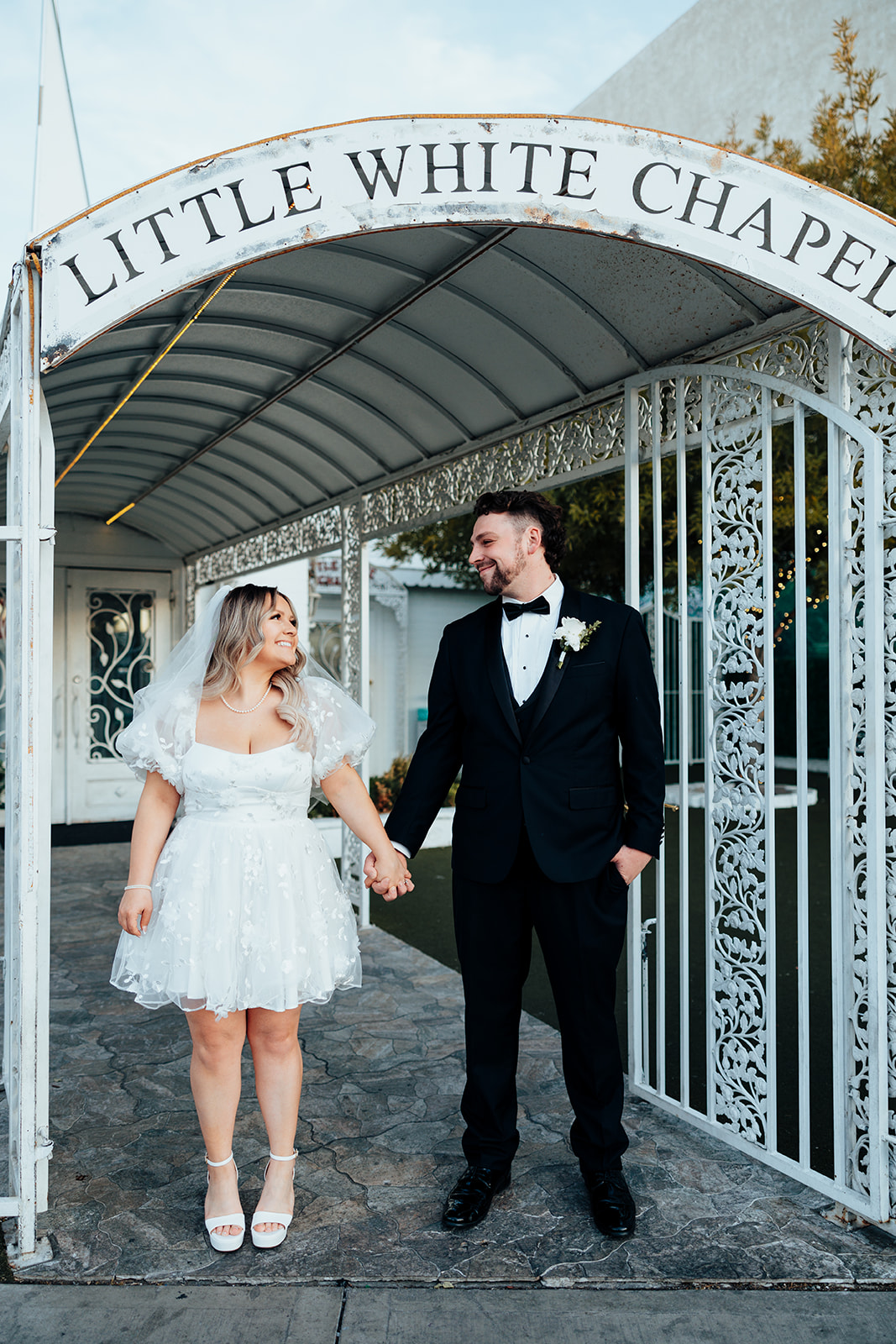 Couple at chapel entrance arch during Little White Wedding Chapel elopement in Las Vegas