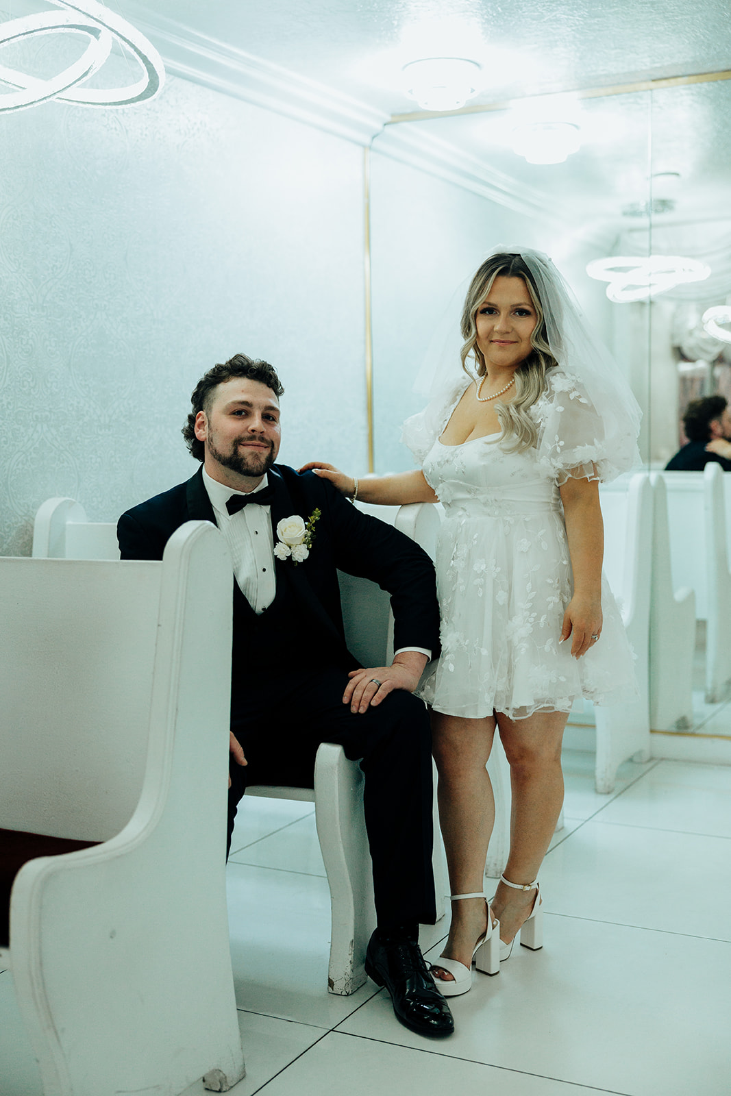 Couple sitting on pew before Little White Wedding Chapel elopement ceremony