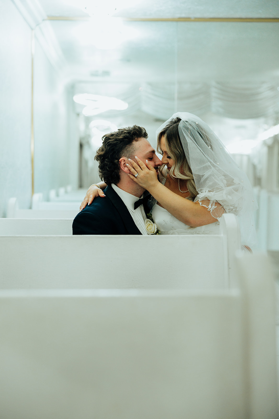 Couple kissing on chapel pew during Little White Wedding Chapel elopement