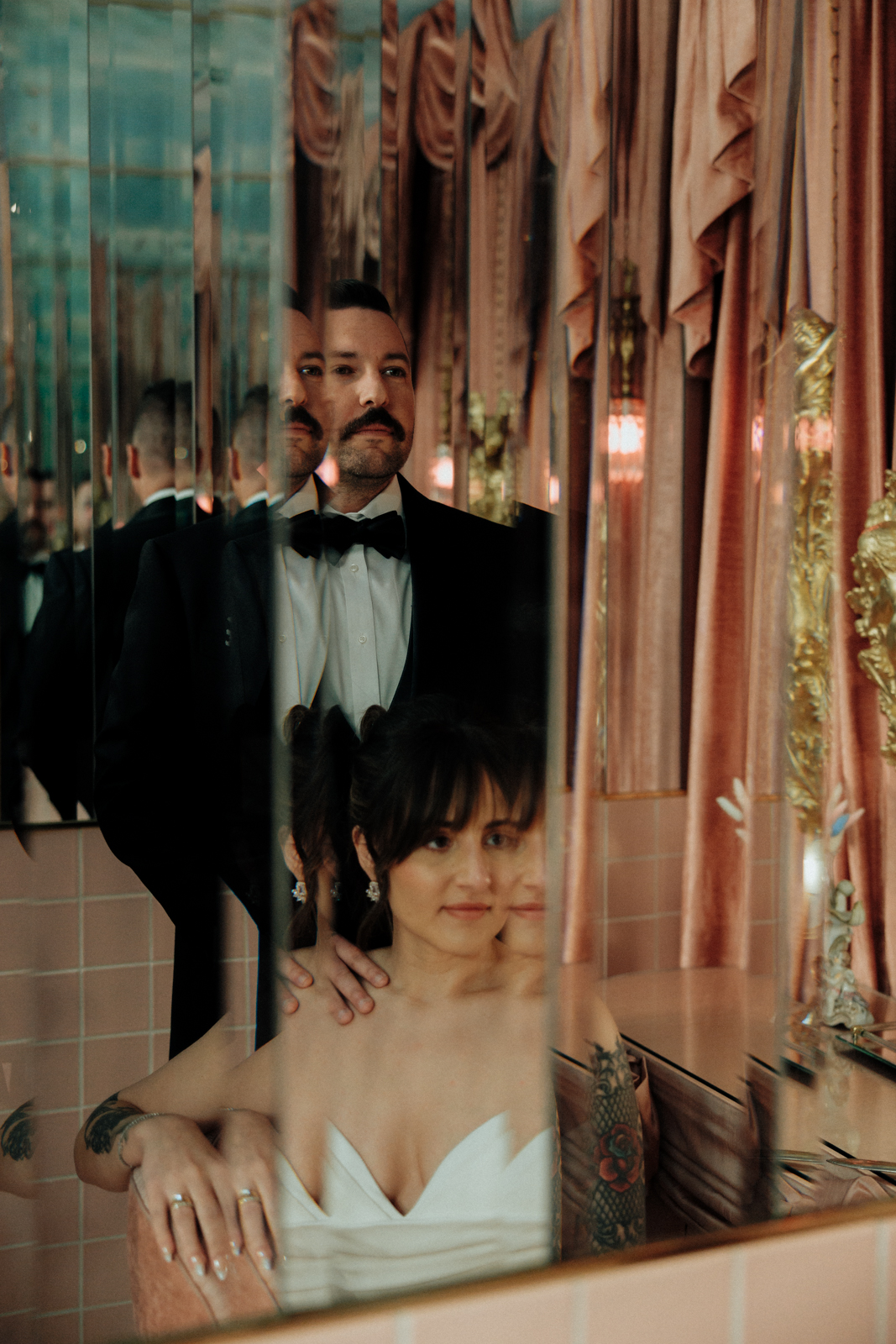 Bride and Groom posing for a Sure Thing bathroom photo in a mirror.